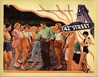 Color picture of a man directing ladies on dance steps.