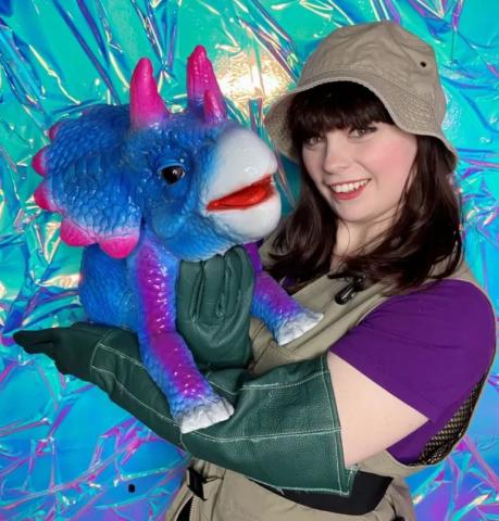 Women holding dino puppet.