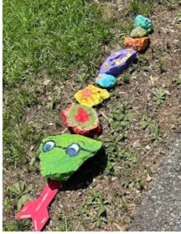 A snake made of rocks. Kind words are written on the rocks.